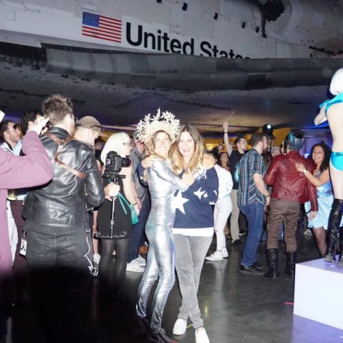 Keynote speaker in a space travel celebration featuring Bill Nye under a Space Shuttle.